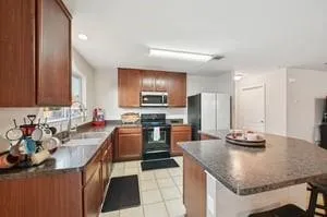 a kitchen with stainless steel appliances granite countertop a sink refrigerator and cabinets