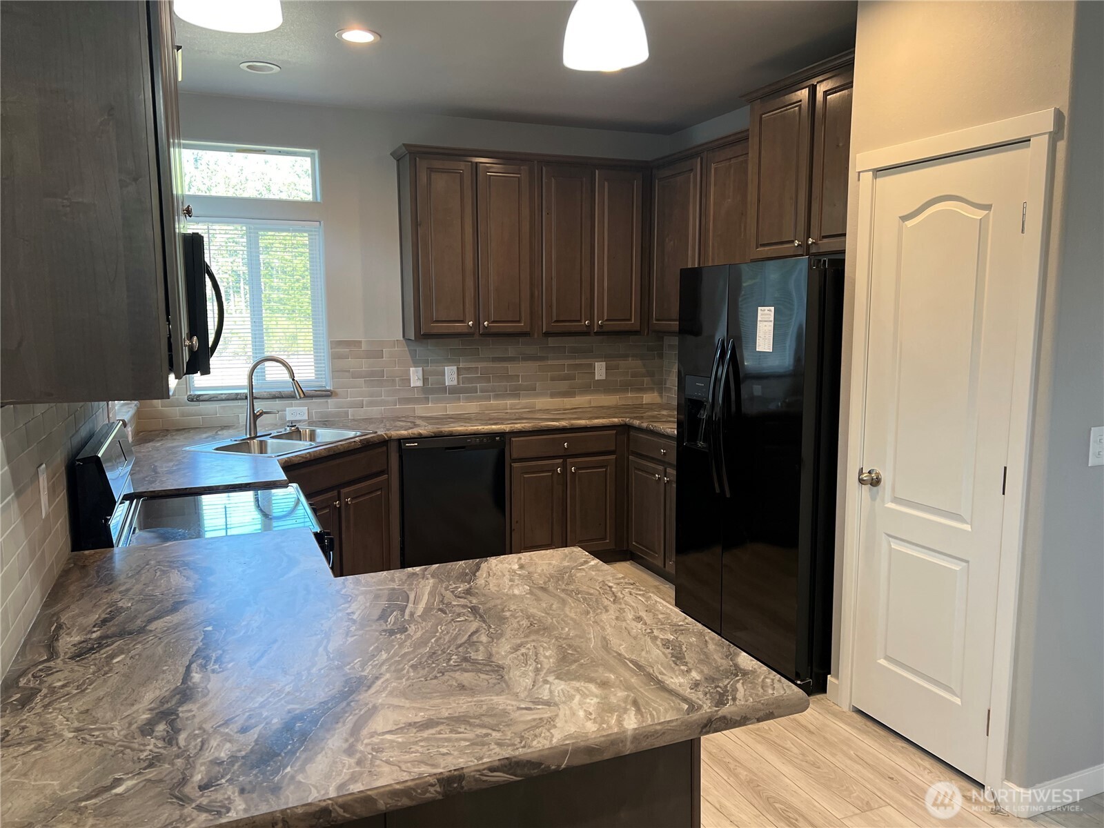 3371 Southeast Bielmeier Road, Unit 79 Port Orchard, WA 98367 - Photo 3 of 16 a kitchen with stainless steel appliances granite countertop a sink stove and refrigerator
