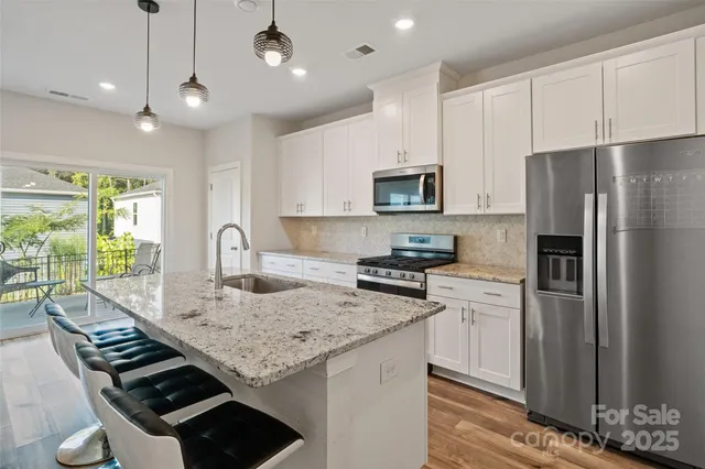 a kitchen with stainless steel appliances granite countertop a sink stove and refrigerator