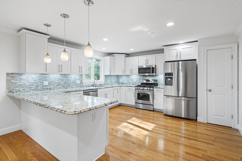 215 Rangeway Road, Unit 31 Billerica, MA 01862 - Photo 8 of 40 a kitchen with stainless steel appliances granite countertop a sink a stove a refrigerator and island with wooden floor