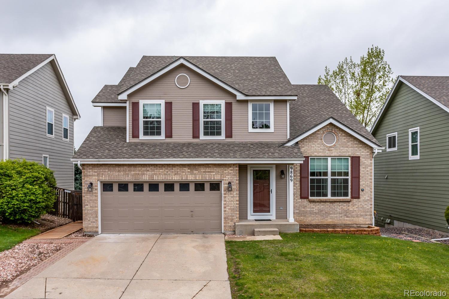 9869 Spring Hill Drive Highlands Ranch, CO 80129 - Photo 1 of 37 a front view of a house with a garden and yard