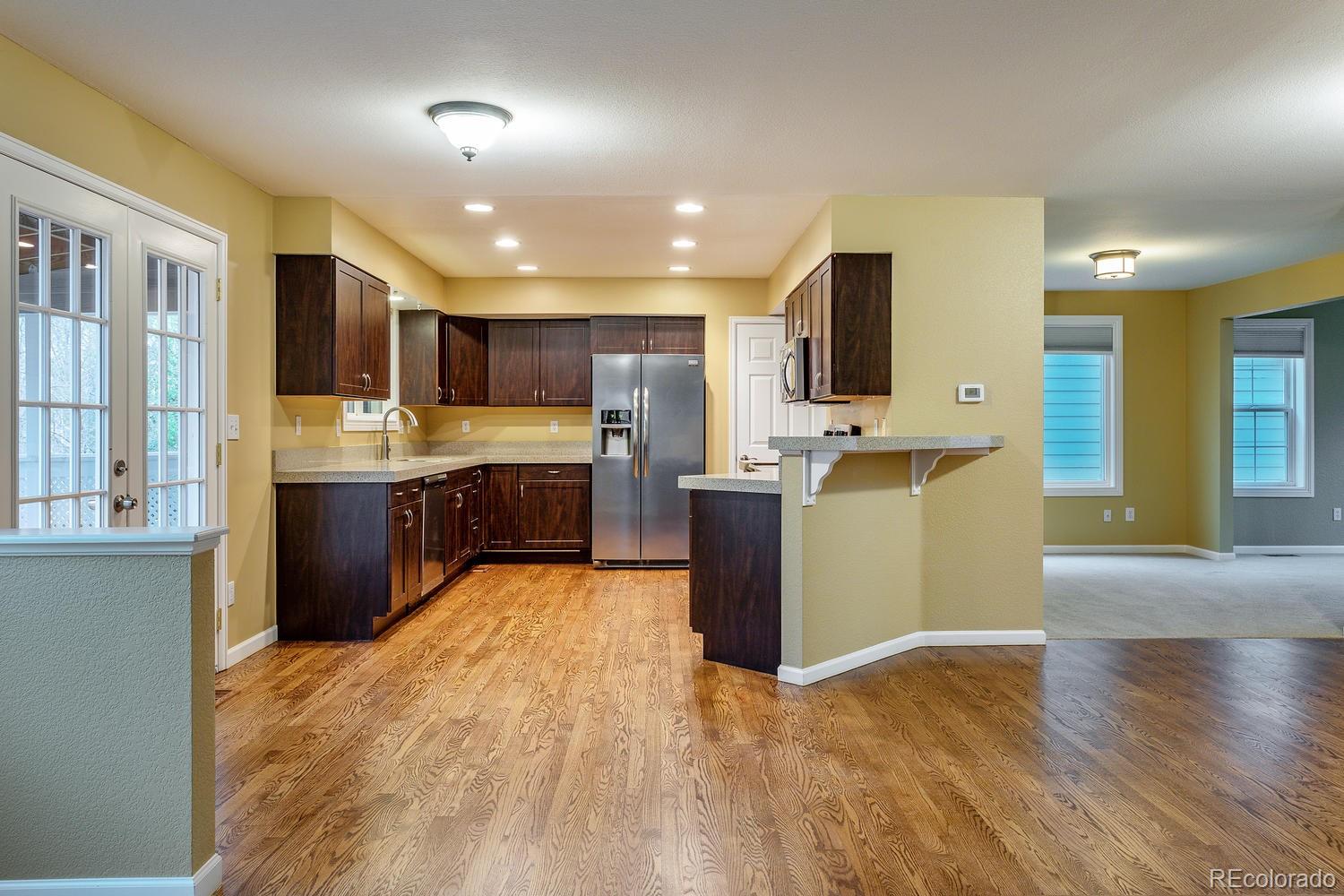 9869 Spring Hill Drive Highlands Ranch, CO 80129 - Photo 12 of 37 a large kitchen with stainless steel appliances granite countertop a refrigerator and a stove top oven