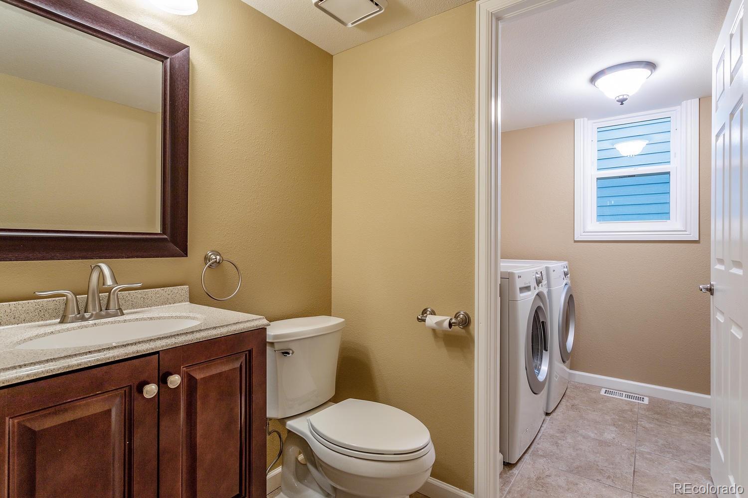 9869 Spring Hill Drive Highlands Ranch, CO 80129 - Photo 13 of 37 a bathroom with a sink a toilet and a mirror