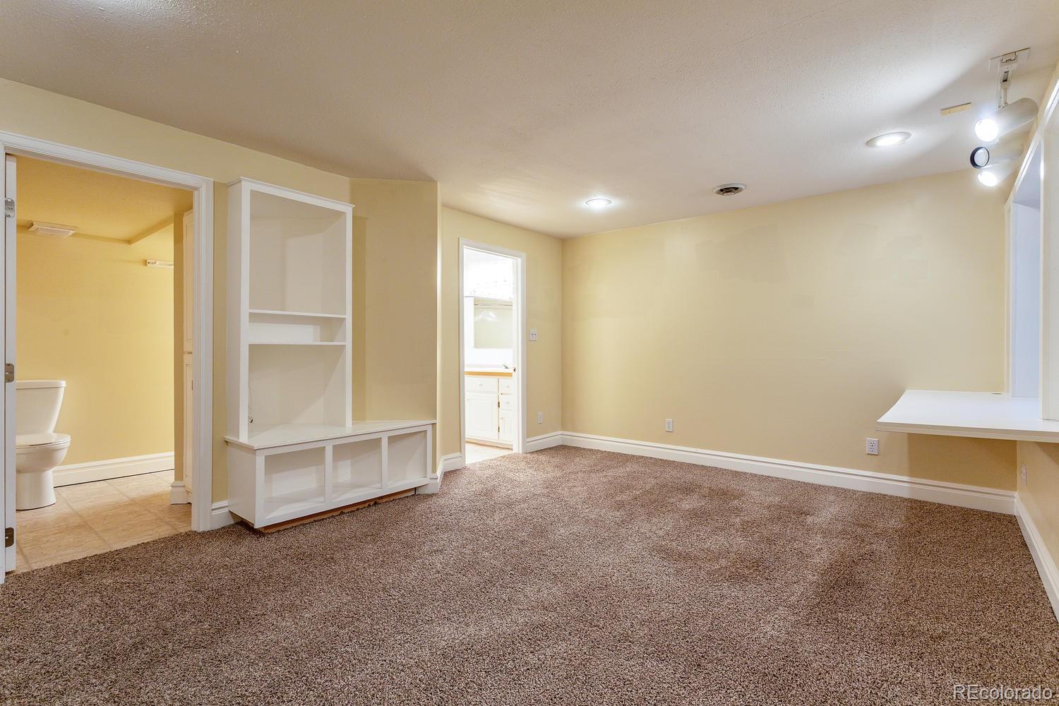 9869 Spring Hill Drive Highlands Ranch, CO 80129 - Photo 24 of 37 an empty room with a fireplace cabinet and window