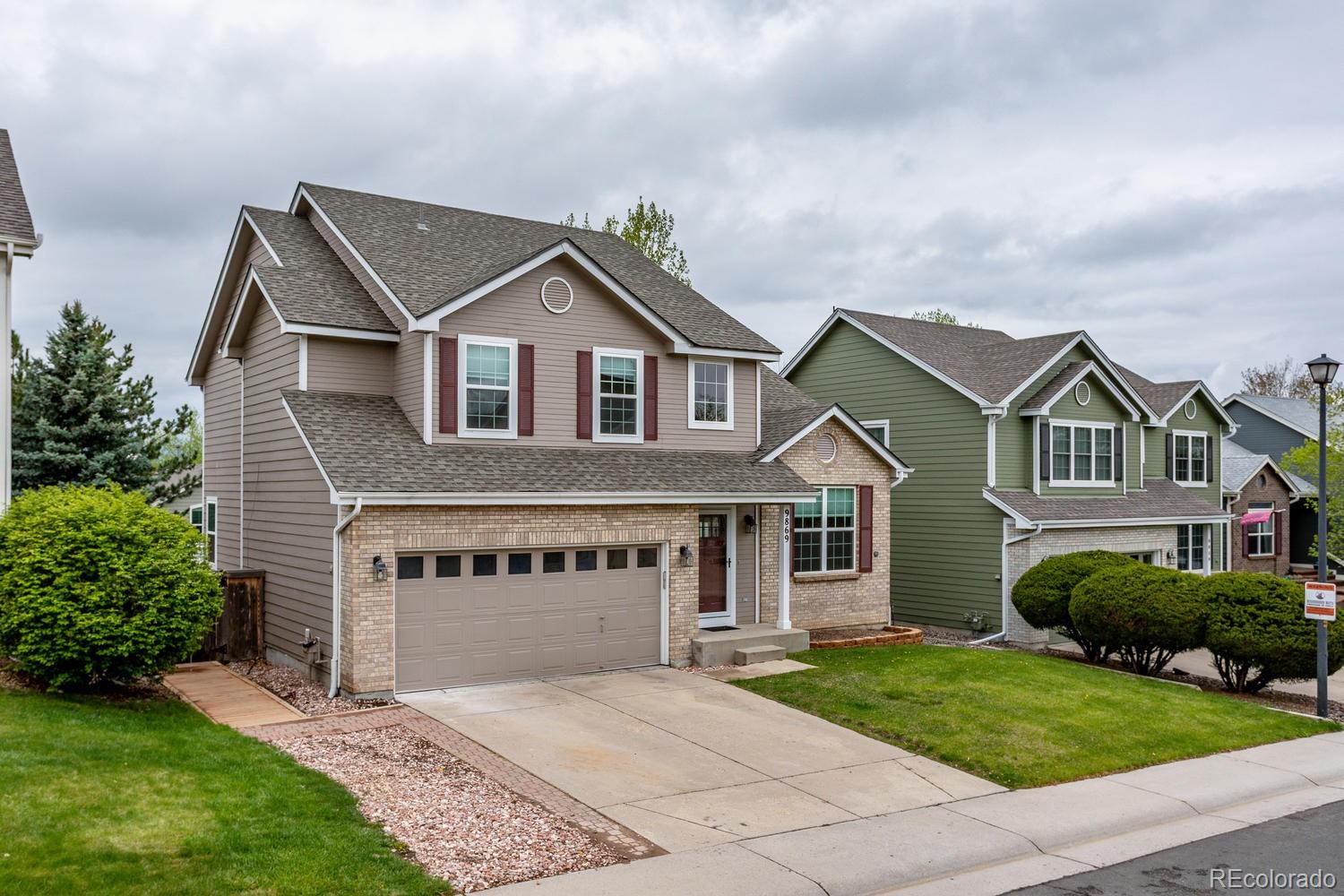9869 Spring Hill Drive Highlands Ranch, CO 80129 - Photo 37 of 37 a front view of a house with a garden and yard