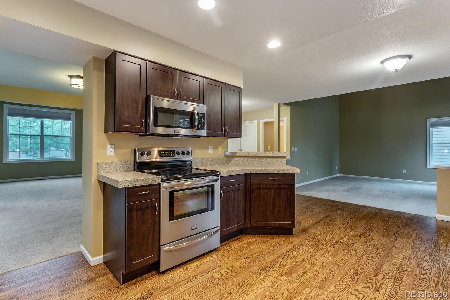 9869 Spring Hill Drive Highlands Ranch, CO 80129 - Photo 8 of 37 a kitchen with granite countertop wooden cabinets stainless steel appliances and a window