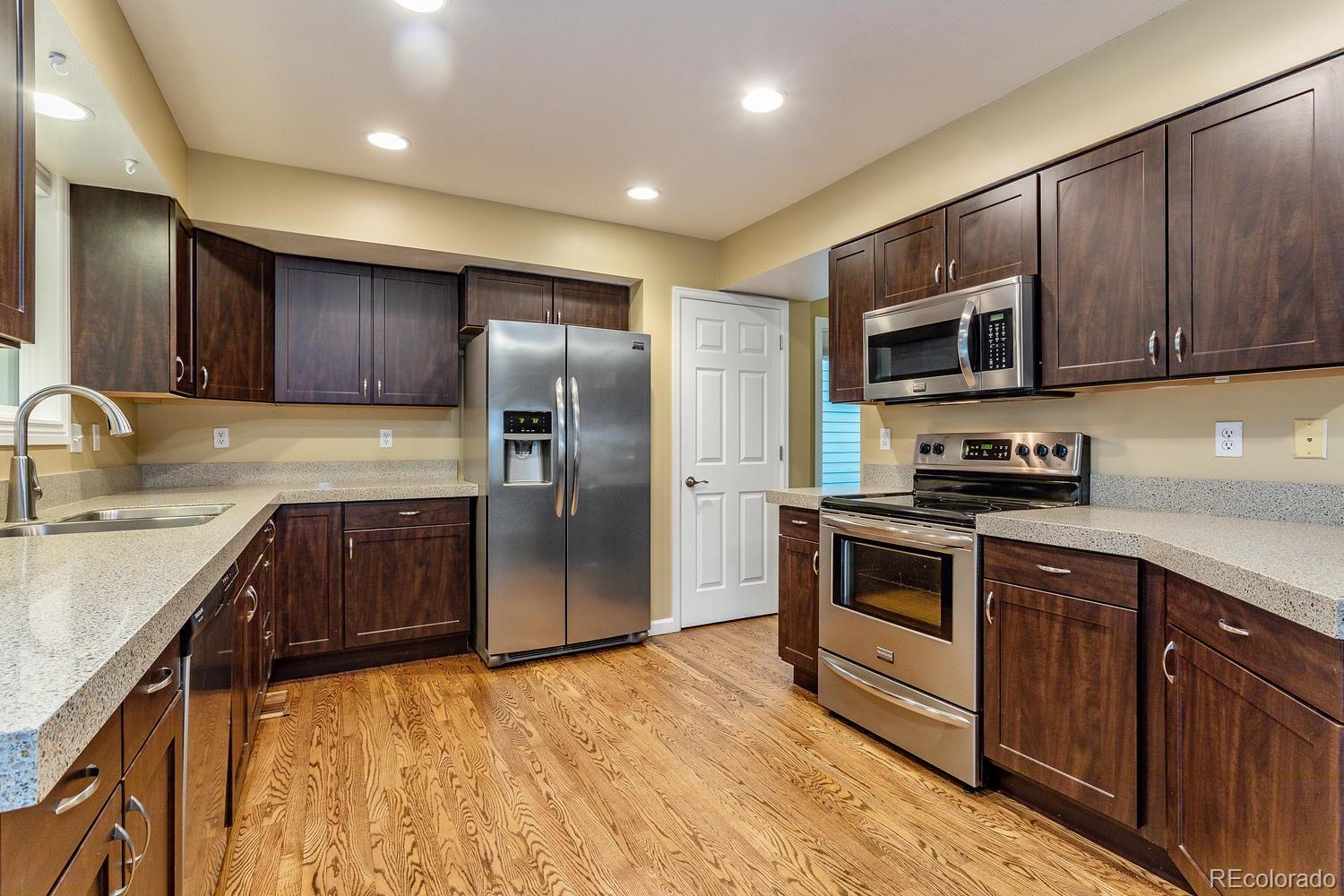 9869 Spring Hill Drive Highlands Ranch, CO 80129 - Photo 9 of 37 a kitchen with granite countertop stainless steel appliances and wooden cabinets