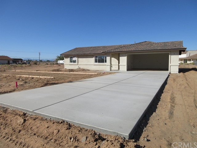 12950 Central Road Apple Valley, CA 92308 - Photo 1 of 1 a front view of a house with a yard