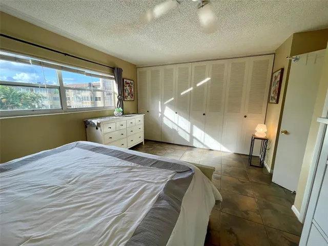 a spacious bedroom with a bed and a large window