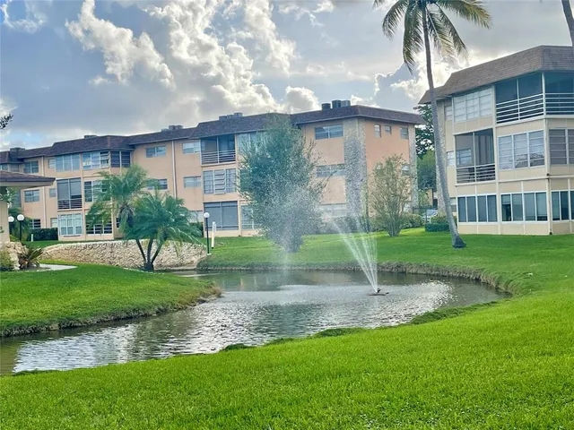 a view of a house with a yard and a fountain
