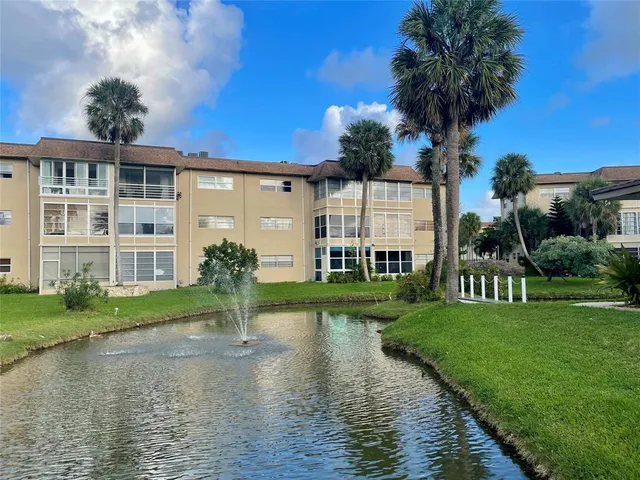 a front view of a house with a yard and potted plants