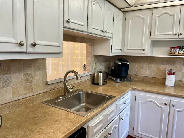 a kitchen with stainless steel appliances granite countertop a sink a stove and cabinets