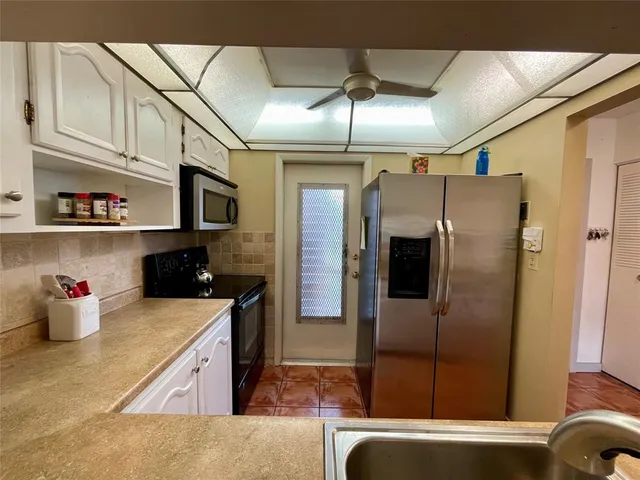 a kitchen with stainless steel appliances granite countertop a refrigerator a sink and dishwasher
