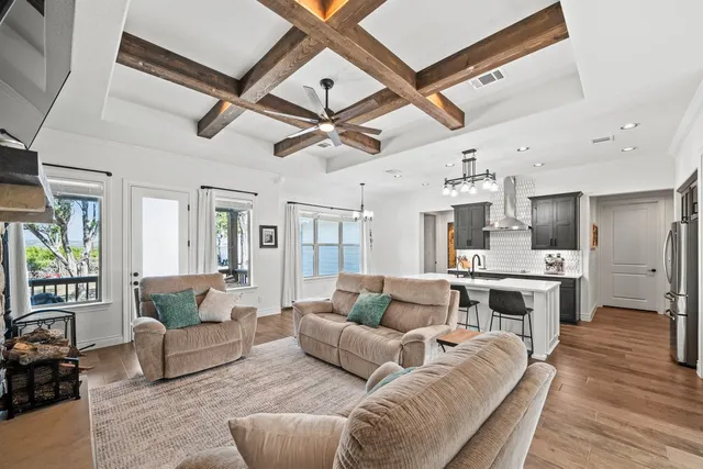 a living room with furniture kitchen view and a large window