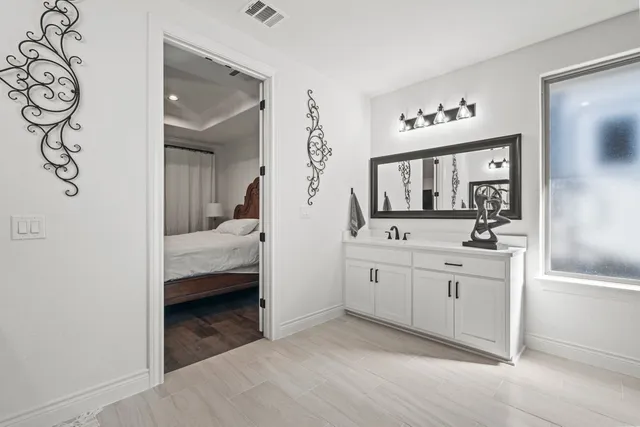 a en suite bathroom with a double vanity sink and a mirror