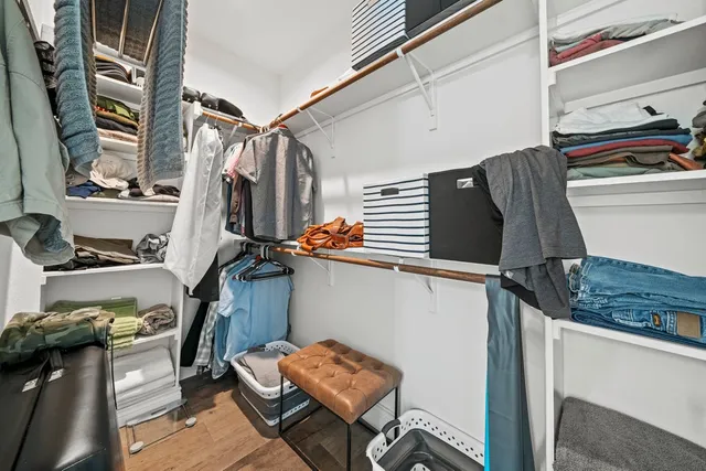 a view of walk in closet with clothes and shoes