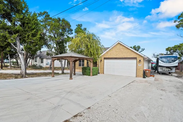 a view of a house with a yard and large tree