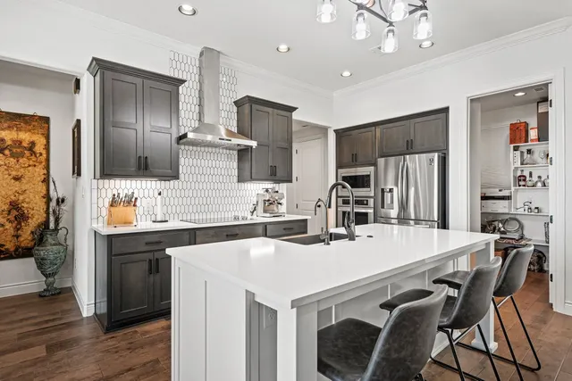 a kitchen that has a sink a counter space and stainless steel appliances