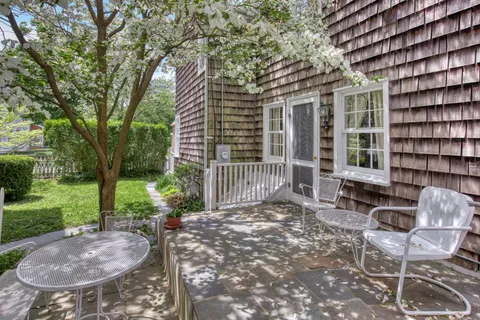 a view of a chair and table in backyard of the house
