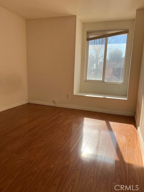 1148 West Cornell Street Rialto, CA 92376 - Photo 11 of 21 a view of an empty room with wooden floor and a window
