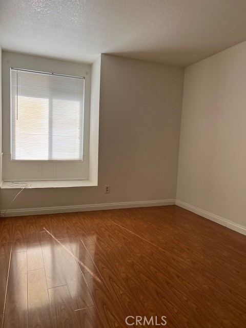 1148 West Cornell Street Rialto, CA 92376 - Photo 12 of 21 an empty room with wooden floor and windows