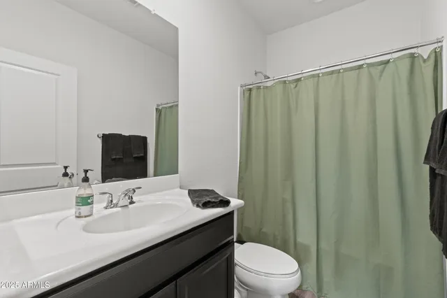 a bathroom with a granite countertop sink toilet and a mirror