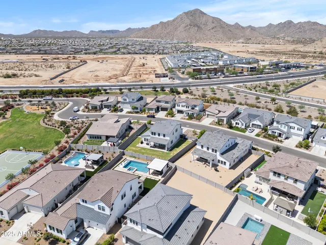 an aerial view of a city with lots of residential buildings and mountain view in back