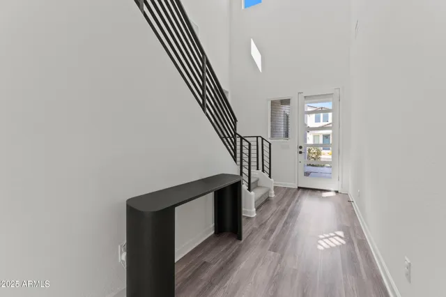 a view of a hallway with wooden floor and staircase