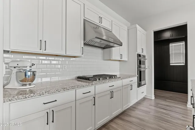 a kitchen with stainless steel appliances granite countertop a sink and a stove