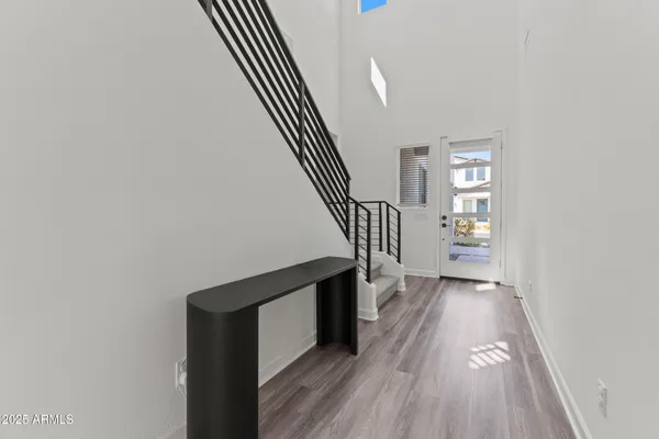 a view of a hallway with wooden floor and staircase