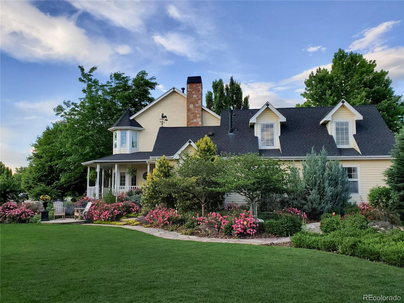 1135 Founders Circle Windsor, CO 80550 - Photo 2 of 45 a front view of a house with a garden and plants