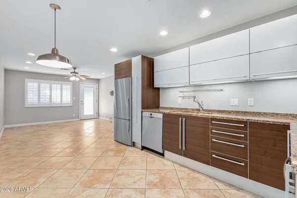 a kitchen with kitchen island granite countertop cabinets and refrigerator