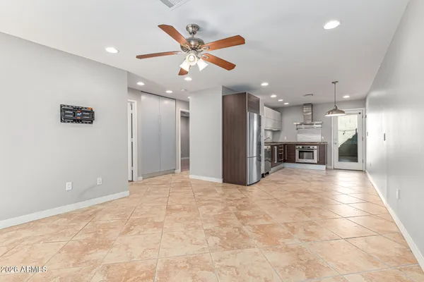 a view of a livingroom with a ceiling fan and kitchen view