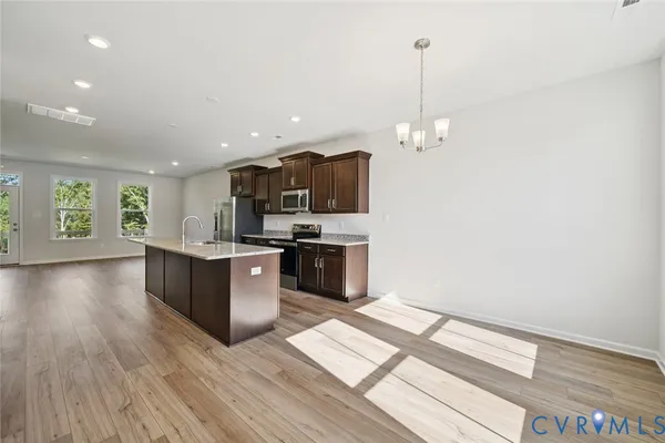 a kitchen with stainless steel appliances granite countertop a stove a sink and a refrigerator