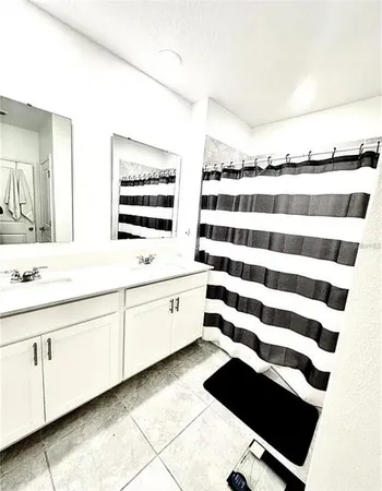 a bathroom with a double vanity sink and mirror
