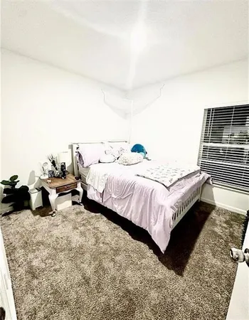 a bed sitting in a bedroom next to a larger window
