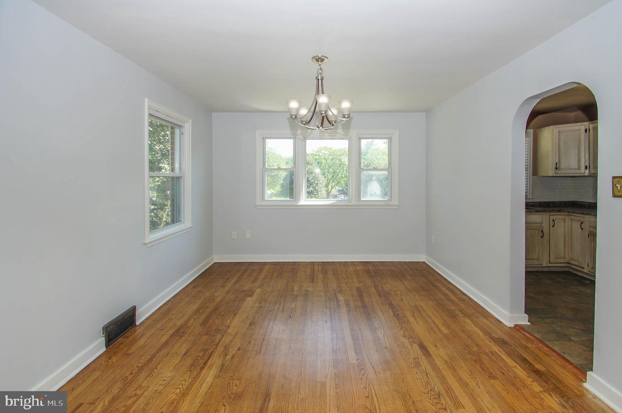 201 Sycamore Road Reading, PA 19611 - Photo 4 of 13 an empty room with wooden floor chandelier and windows
