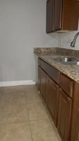 a kitchen with granite countertop a sink and a stove