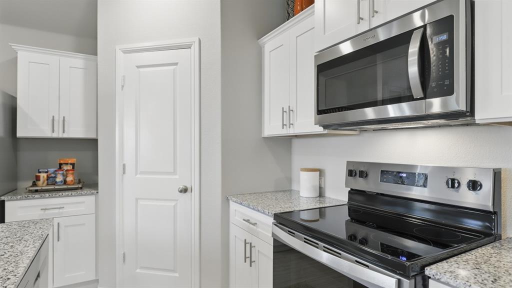336 Pecos Drive Azle, TX 76020 - Photo 5 of 37 a kitchen with stainless steel appliances granite countertop white cabinets and stove
