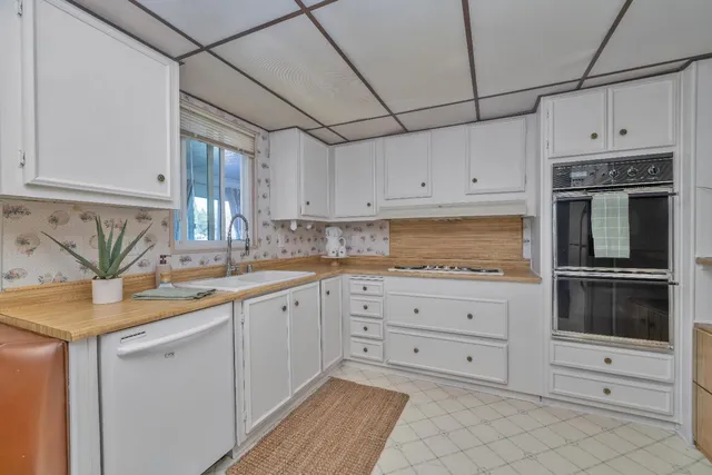 a dining room with stainless steel appliances kitchen island granite countertop a sink and cabinets