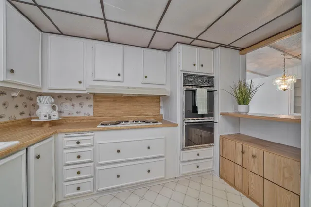 a kitchen with granite countertop white cabinets and stainless steel appliances