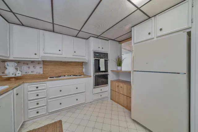 a kitchen with granite countertop white cabinets and stainless steel appliances
