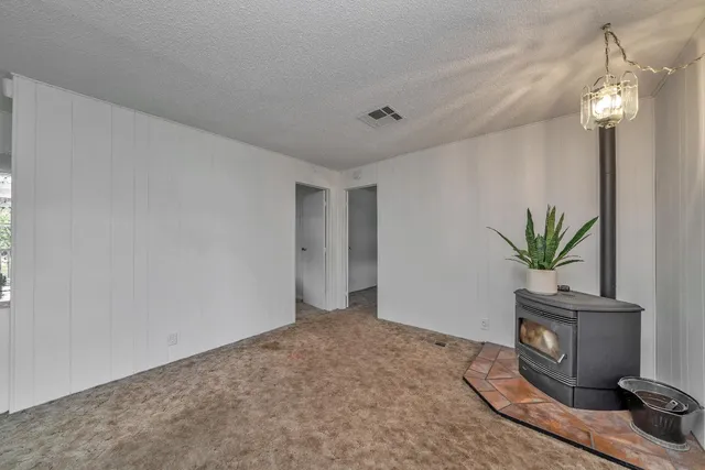 a view of an empty room with floor to ceiling window and stairs