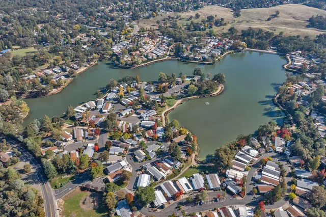 an aerial view of water body with boats and residential houses with outdoor space