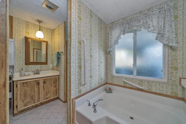 a bathroom with a tub sink and mirror