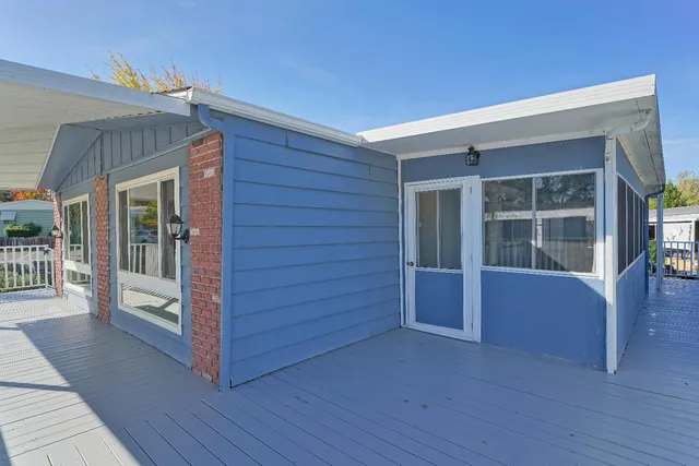 a living room with large windows and a ceiling fan