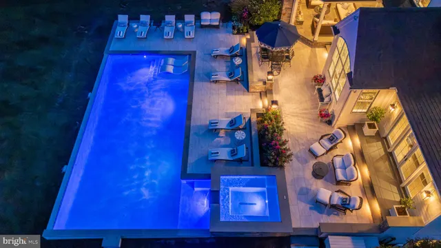 a dining room with wooden floor a chandelier a glass table and chairs