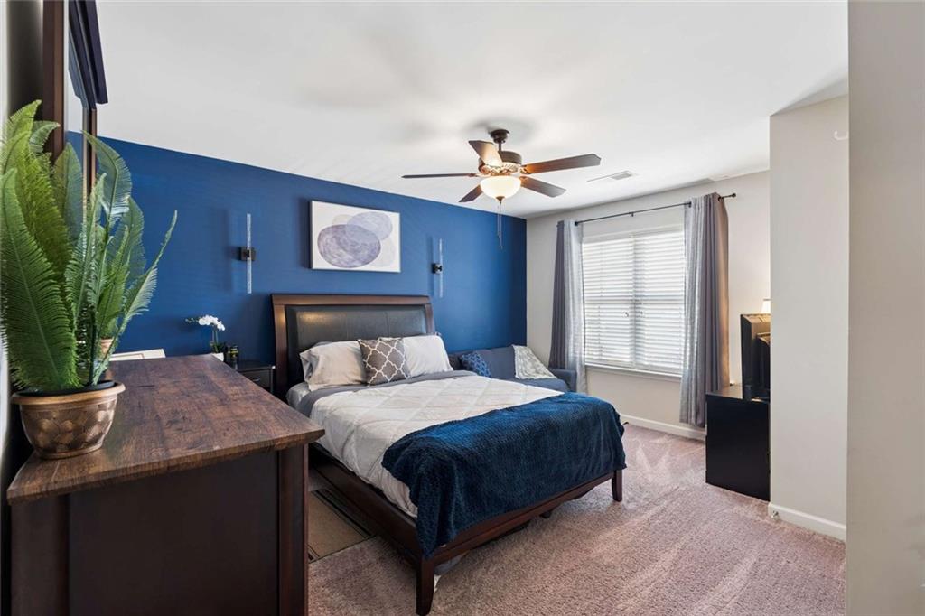 4065 McClendon Way Rex, GA 30273 - Photo 10 of 16 a bedroom with a bed and a chandelier