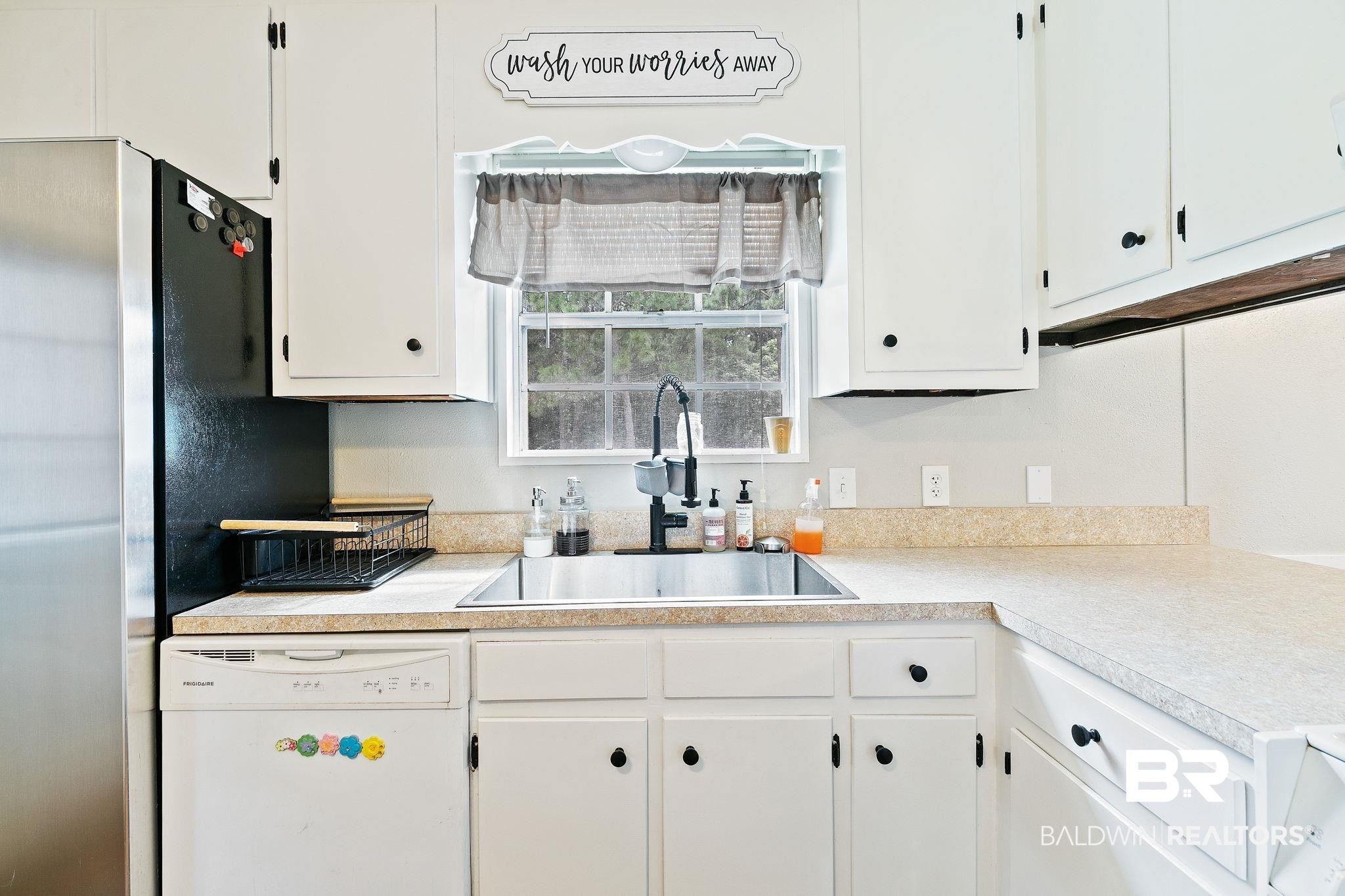 14 Lee Circle Daphne, AL 36527 - Photo 32 of 83 Kitchen featuring sink, white cabinets, white dishwasher, and stainless steel fridge