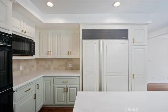 a kitchen with granite countertop a sink stainless steel appliances and cabinets